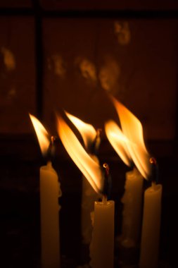 Karanlıkta mum ışığında yanan mumlar.