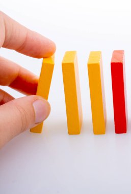 Beyaz arka planda el ele tutuşan renkli domino taşları