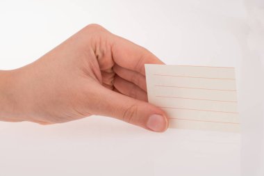 Beyaz bir arkaplanda bir kağıt parçası tutuyor.