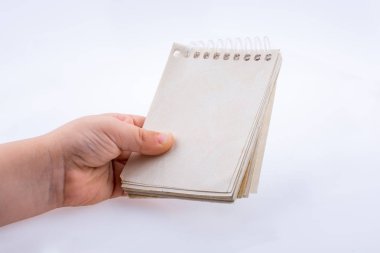 Beyaz arkaplanda kahverengi renkli bir not defteri var.