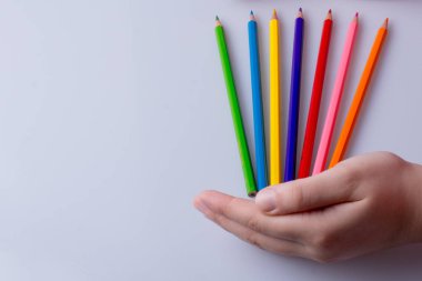 Beyaz arkaplana yerleştirilmiş el ele tutuşan kalemler