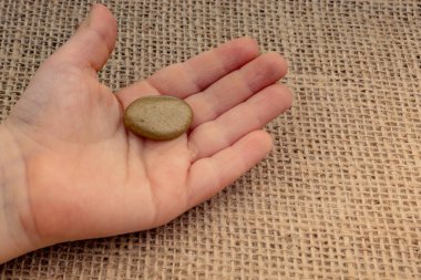 Elinde küçük altın renkli çakıl