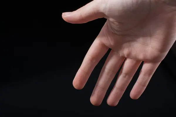 黒の背景に一部見られる子供の手の5本の指 — ストック写真