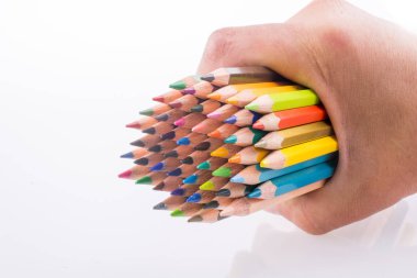 Beyaz arkaplanda el ele tutuşan renkli kalemler