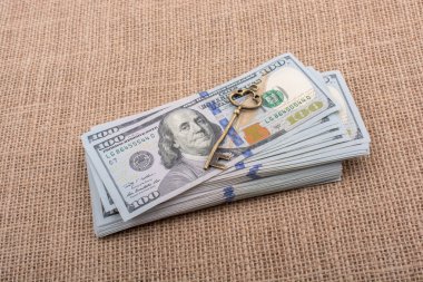 Bir tuval üzerinde geçmişe dönük anahtar ve Amerikan doları destesi