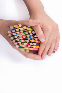 Beyaz arkaplanda el ele tutuşan renkli kalemler