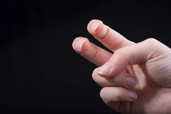 黒い背景に一部見られる子供の手の2本の指 — ストック写真