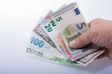 Beyaz arka planda el ele tutuşan Amerikan doları banknotları