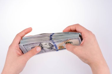 İnsan eli, Amerikan doları banknotunu beyaza izole edilmiş olarak tutuyor.