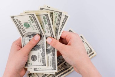 İnsan eli, Amerikan doları banknotunu beyaza izole edilmiş olarak tutuyor.
