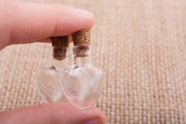 Kalp şeklinde cam şişeler el ele tutulur.