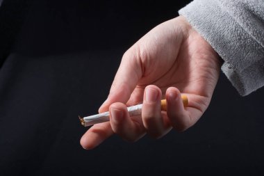 El siyah arka planda sigara dağıtıyor.