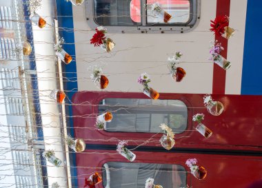 İplere asılı çiçekli bitkisel çay şişeleri