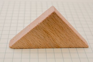 Kağıt üzerinde bir üçgenin üzerinde bir tahta parçası.