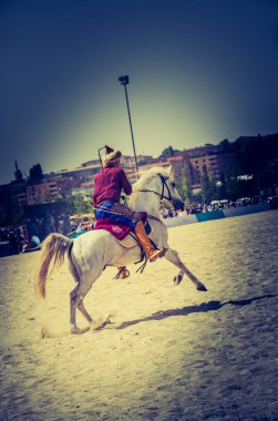 Osmanlı atlısı etnik kıyafetleriyle atına biniyor.