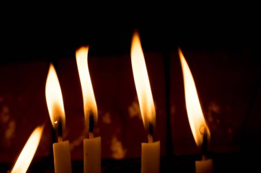 Karanlıkta mum ışığında yanan mumlar.