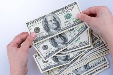 İnsan eli, Amerikan doları banknotunu beyaza izole edilmiş olarak tutuyor.