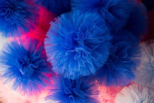 Set of different colours and shapes of pompoms in an open market