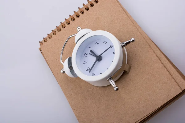 Cuaderno Espiral Reloj Despertador Sobre Fondo Blanco — Foto de Stock