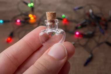 Kalp şeklinde cam şişe elinde ışıkların