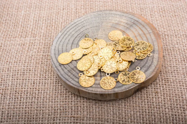Plenty of fake gold coins are on a piece of wood