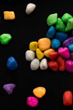 Siyah arkaplanda küçük renkli çakıl yığınları