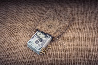 Retro anahtar ve bir çuval dolusu Amerikan doları tuvalde.