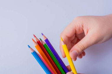 Beyaz arkaplana yerleştirilmiş el ele tutuşan kalemler