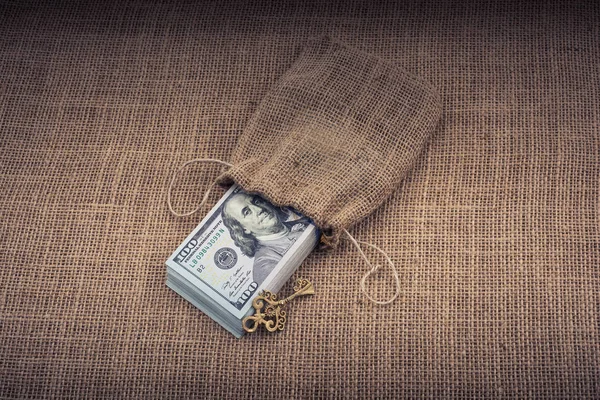 Retro anahtar ve bir çuval dolusu Amerikan doları tuvalde.