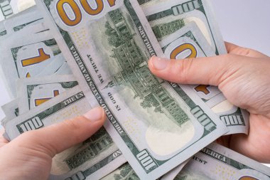 İnsan eli, Amerikan doları banknotunu beyaza izole edilmiş olarak tutuyor.