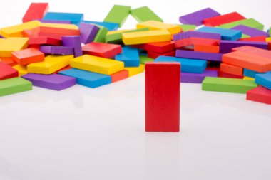 Beyaz arkaplanda renkli domino taşıyla el oyunu