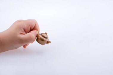 Küçük bir ketttle beyaz bir arka plan üzerinde elinde tutan çocuk