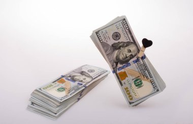 100 dolarlık banknotlar ve bir kalp klipsi.