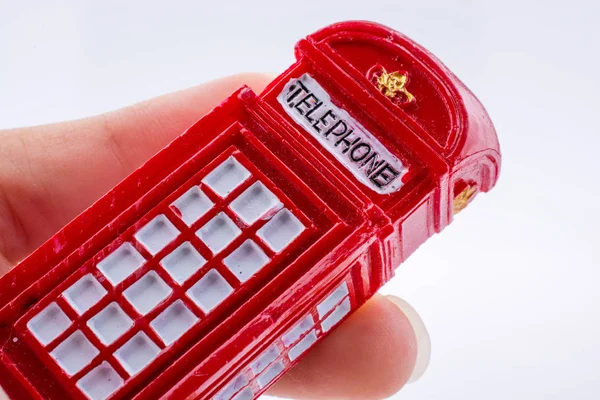 Mano Sosteniendo Una Cabina Telefónica Color Rojo Sobre Fondo Blanco — Foto de Stock