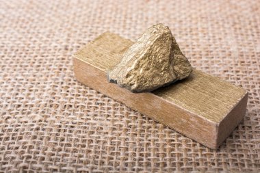 keten bir tuval üzerine küçük altın renkli taş