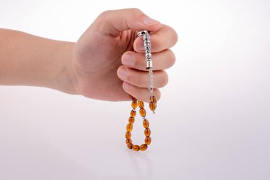 Beyaz bir arka plan üzerinde bir tespih tutan el