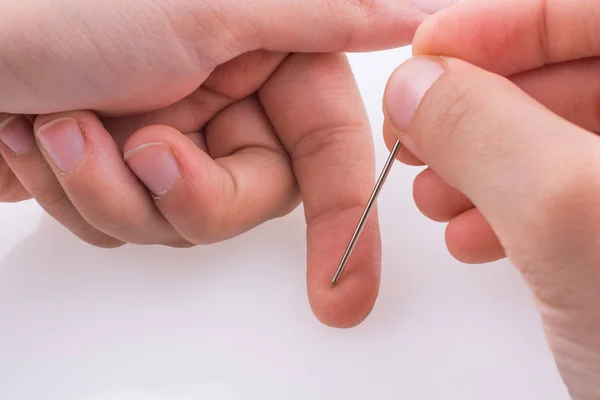 Hand Met Een Naald Een Witte Achtergrond — Stockfoto