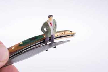 Beyaz arka planda insan figürünün yanında el çakısı.