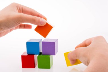 Beyaz arka planda renkli küplerle el oynamak