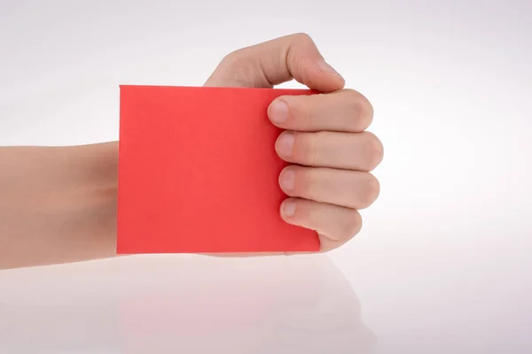 Mano Sosteniendo Papel Nota Rojo Sobre Fondo Blanco — Foto de Stock