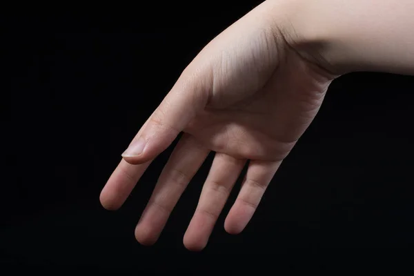 黒の背景に一部見られる子供の手の5本の指 — ストック写真