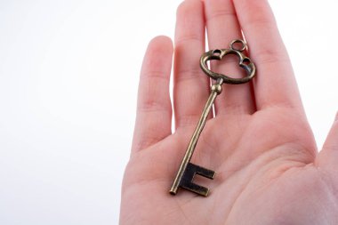 Beyaz arka planda eski moda metal bir anahtar tutan el.