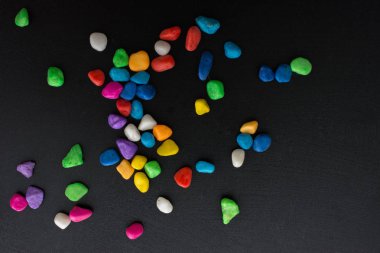 Siyah arkaplanda küçük renkli çakıl yığınları