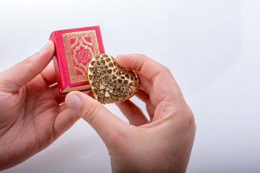 Kalp şekli ve İslam kutsal kitabı Kur'an tutan el