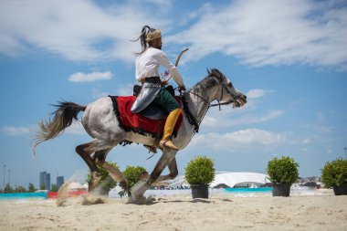 Osmanlı atlısı etnik kıyafetleriyle atına biniyor.