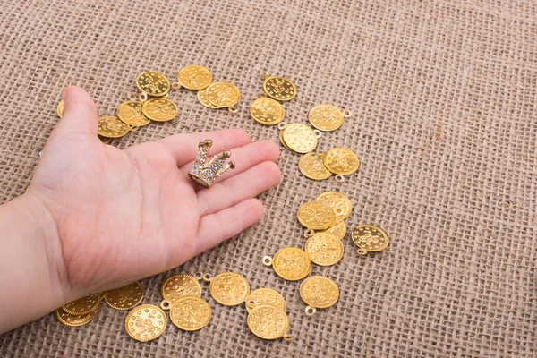 Monedas Oro Falsas Alrededor Pequeña Corona Modelo Mano — Foto de Stock