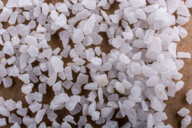 Tahta zemine saçılmış küçük beyaz taşlar.