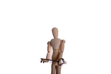 Beyaz arka planda elinde antika bir altın anahtar tutan kukla.