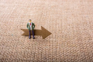 Heykelcik adam bir okla tuval arka plan üzerinde yol açtı.