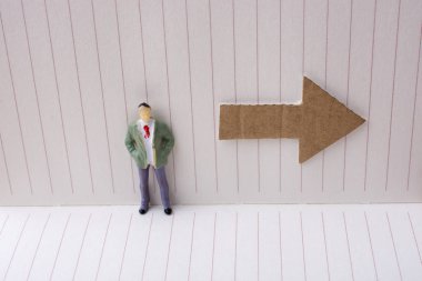 Heykelcik ve tuval üzerine bir defter kağıt ok